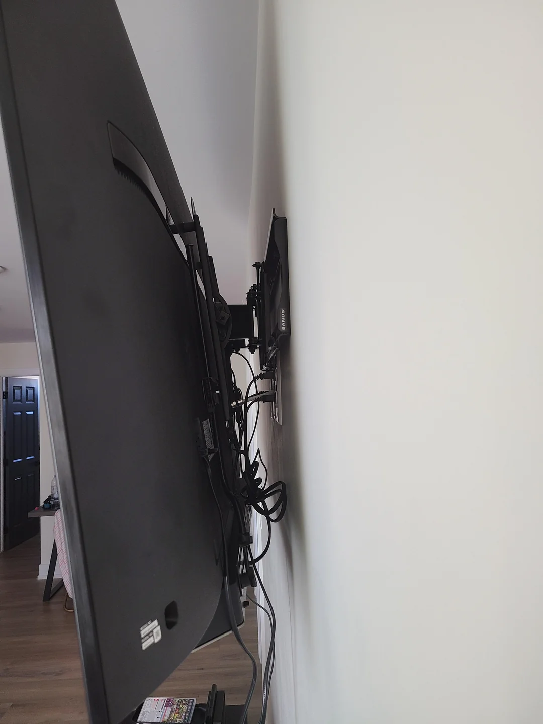 A wall mounted flat screen tv sitting on top of a wooden floor