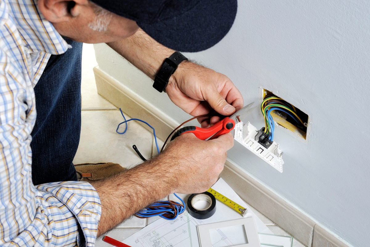 A man working on electrical wiring in his home