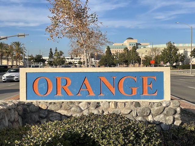 A sign that says orange in Orange California in front of a street