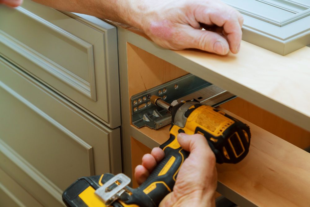A man holding a drill and a screwdriver